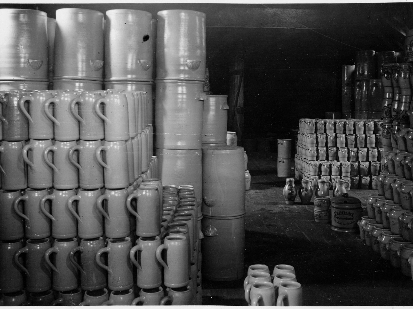 Historisches Bild von Steinzeugkrügen vor einem Kannenofen aus der Erzählung Kleines Feuer von Roland Giefer