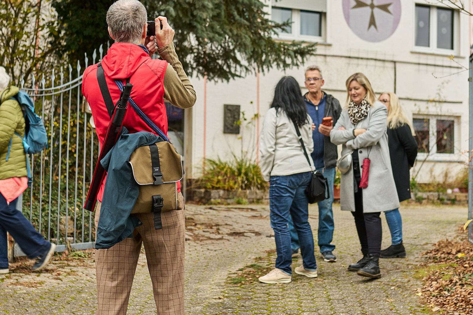 Teilnehmer fotografiert Fassadengestaltung während eines Stadtspaziergangs in Höhr-Grenzhausen, Modellvorhaben Innenstadt-Impulse des Landes Rheinland-Pfalz.