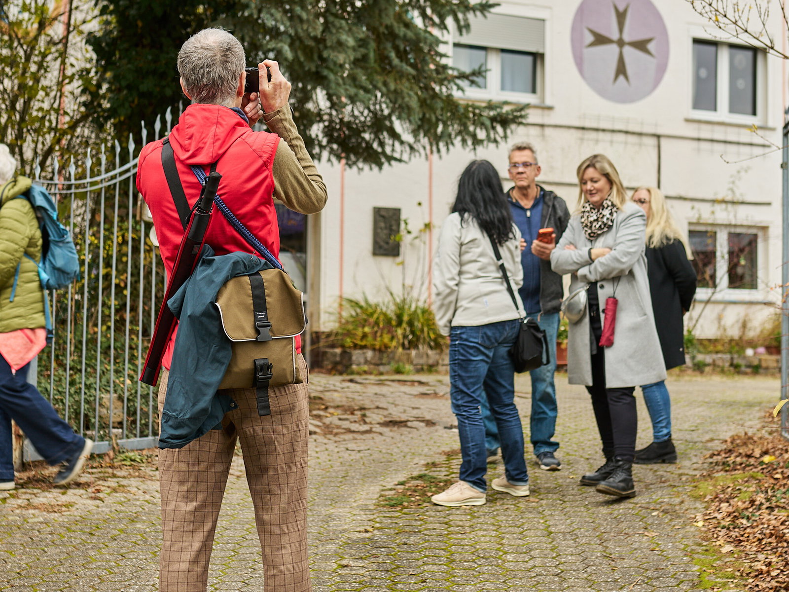 Teilnehmer fotografiert Fassadengestaltung während eines Stadtspaziergangs in Höhr-Grenzhausen, Modellvorhaben Innenstadt-Impulse des Landes Rheinland-Pfalz.
