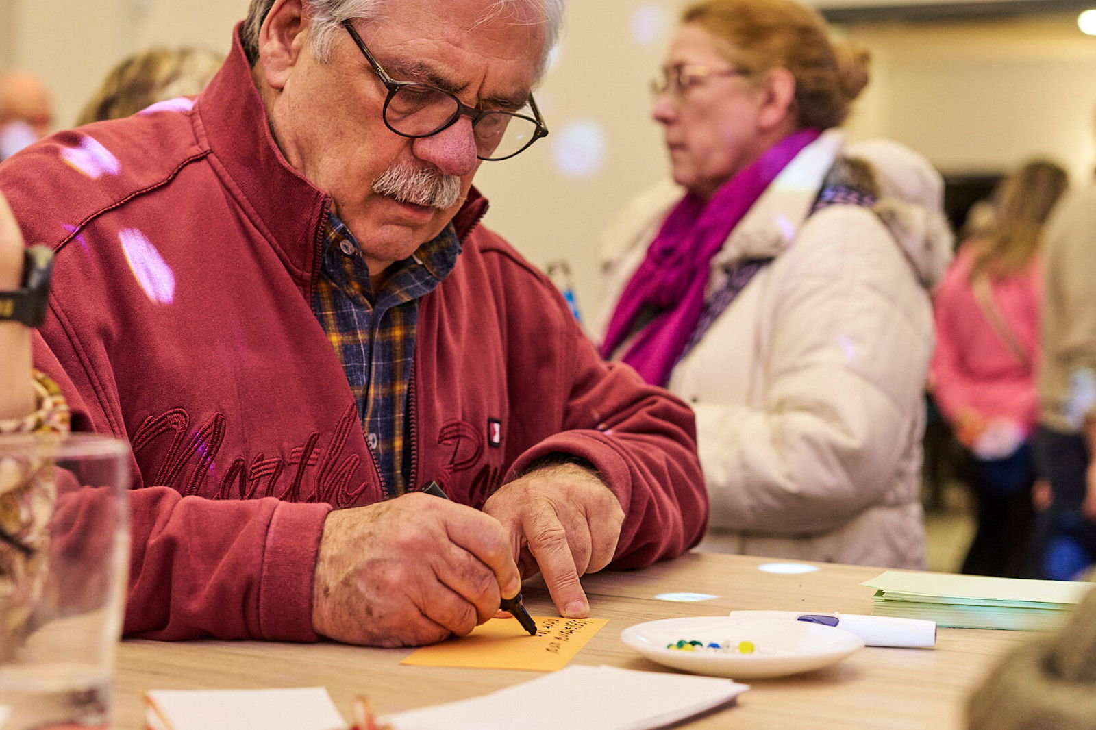 Teilnehmer schreibt konzentriert eine Idee auf eine Karte während einer Zukunftswerkstatt des Modellvorhabens Innenstadt-Impulse.