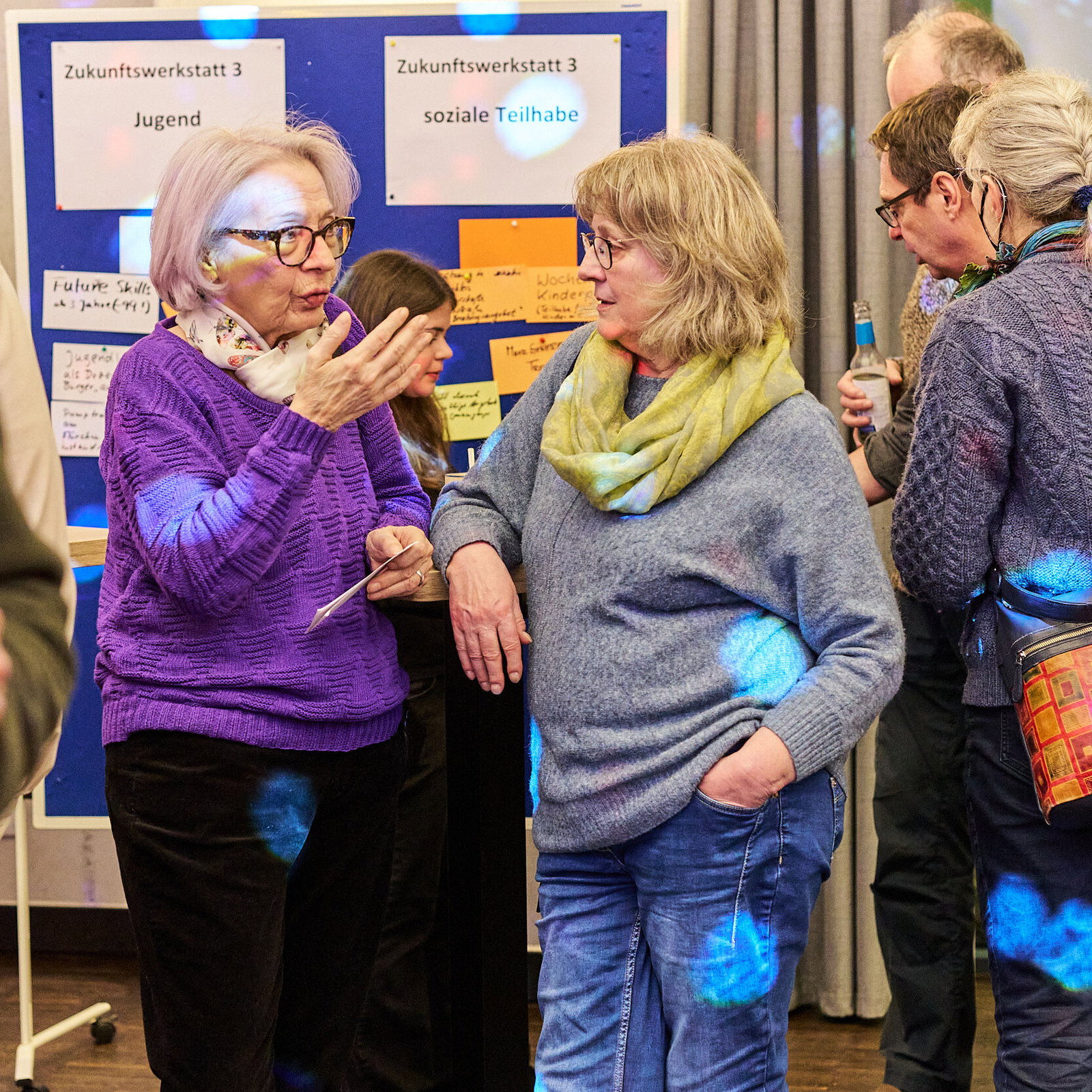 Teilnehmende im Gespräch vor Pinnwänden bei einer Zukunftswerkstatt zur sozialen Teilhabe im Modellvorhaben Innenstadt-Impulse.